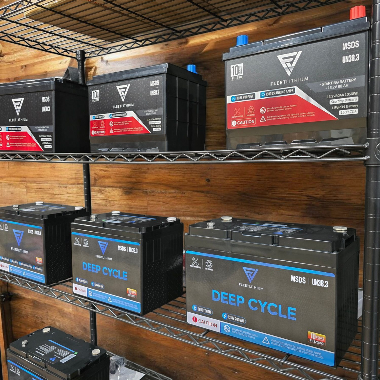 Fleet Lithium BlueMax Marine 12V 195Ah LiFePO4 Deep Cycle Battery (Group 27) shown from a slightly elevated angle on a metal shelf, with other Fleet Lithium batteries on shelves above and below.