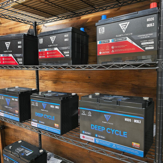 Fleet Lithium BlueMax Marine 12V 195Ah LiFePO4 Deep Cycle Battery (Group 27) shown from a slightly elevated angle on a metal shelf, with other Fleet Lithium batteries on shelves above and below.