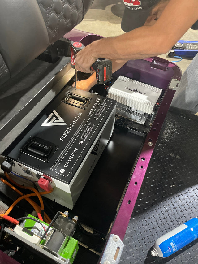 Fleet Lithium 51V 168Ah Fleet Lithium Battery Bundle — NexGen BMS being installed in a golf cart, with a person’s hands using a power drill to secure the battery into the compartment.