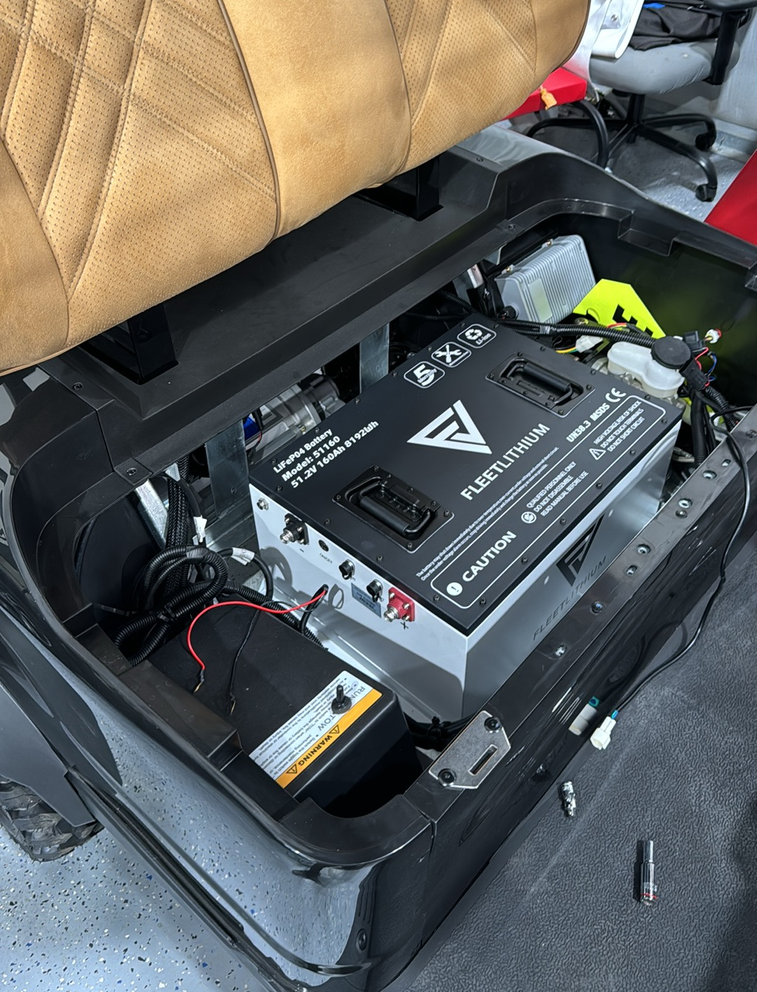 Fleet Lithium 51V 168Ah Fleet Lithium Battery Bundle — NexGen BMS installed in a golf cart, showing the battery secured in the compartment alongside other vehicle components.