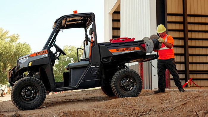51V 168Ah Fleet Lithium Battery Bundle — NexGen BMS — A Polaris PRO XD UTV in an outdoor construction setting, with a worker in a hard hat and safety vest unrolling cable from the bed of the vehicle.