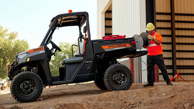 51V 168Ah Fleet Lithium Battery Bundle — NexGen BMS — A Polaris PRO XD UTV in an outdoor construction setting, with a worker in a hard hat and safety vest unrolling cable from the bed of the vehicle.