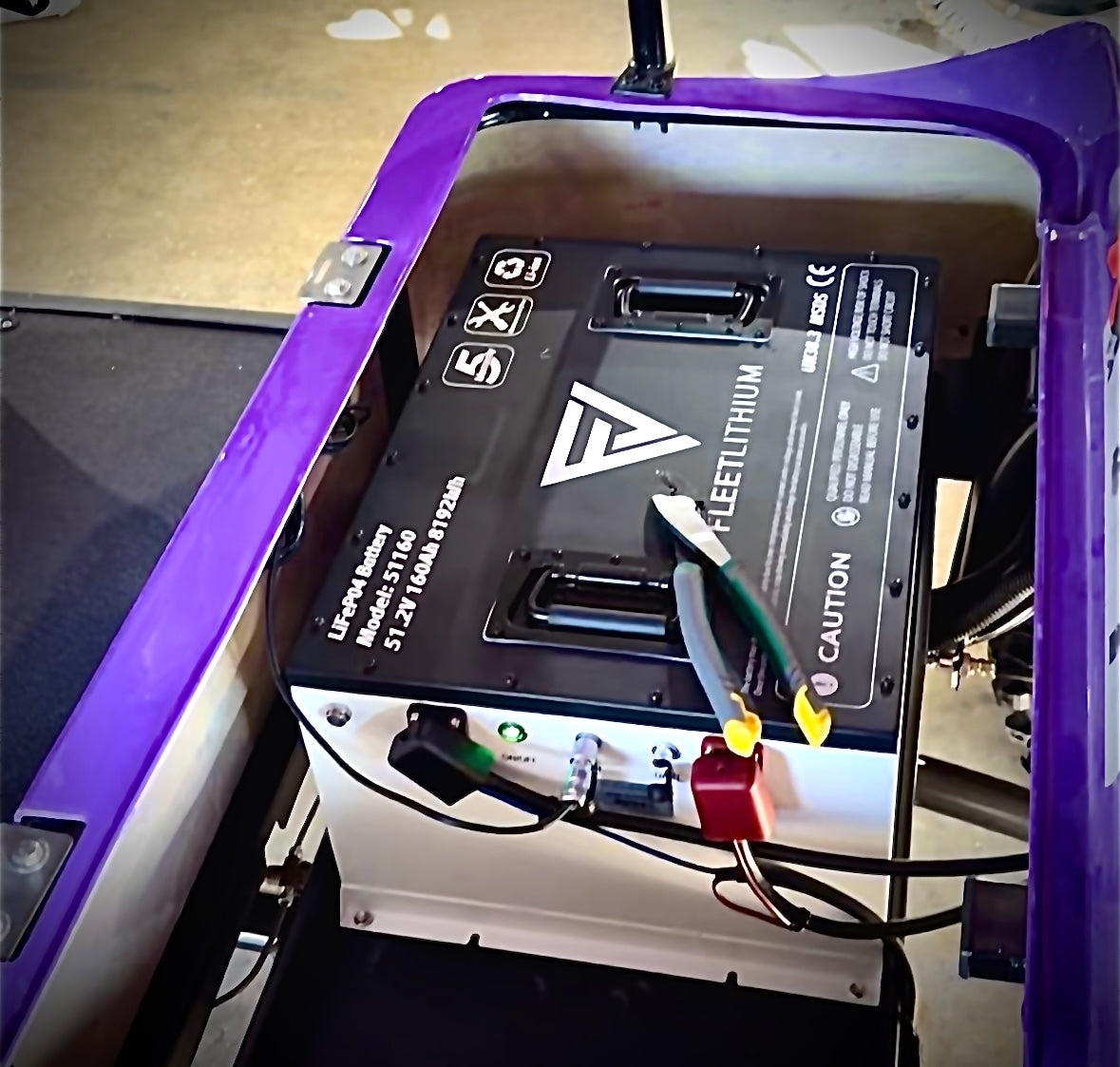 Fleet Lithium 51V 168Ah Fleet Lithium Battery Bundle — NexGen BMS installed in a golf cart, with a pair of pliers resting on top of the battery, showcasing its compact fit.